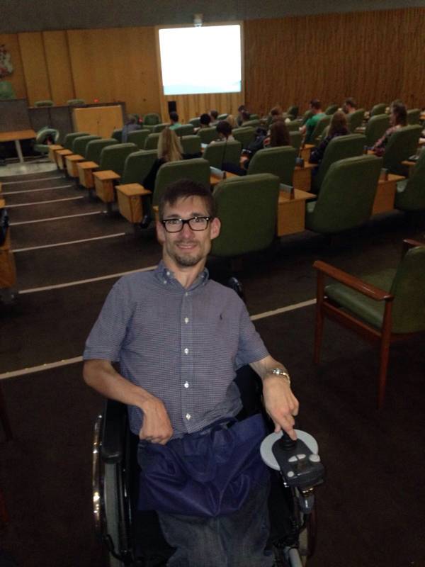 Mann im Rollstuhl vor einem Sitzungssaal